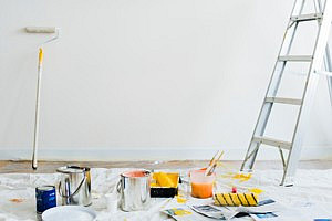 paint pots and ladder against pale blue wall in an organised home redecoration project